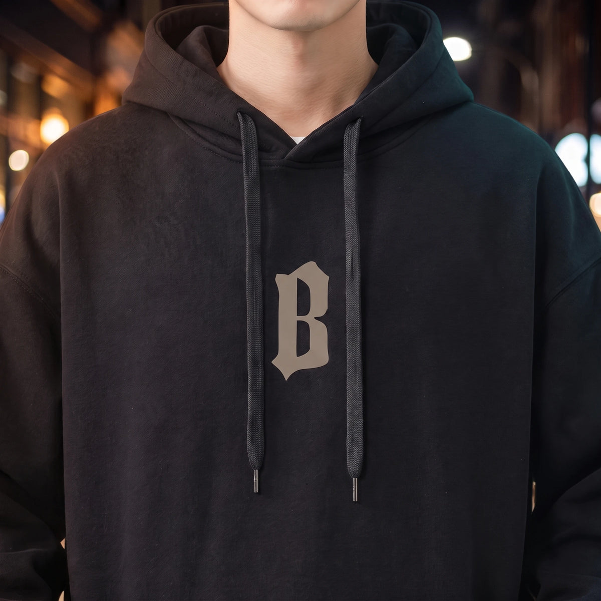 Vallor Gothic Hoodie in black, close-up of the blackletter B chest print, drawcords and fleece texture