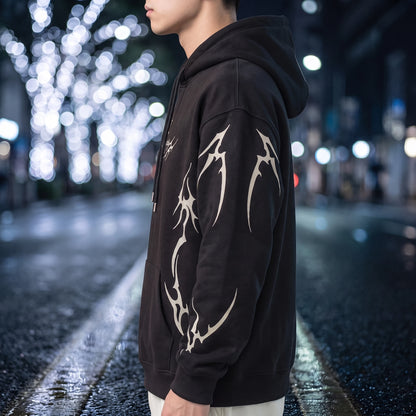 Vaskel Thorn Hoodie in Black, side view showing the tribal flame print running down the sleeve and the drop shoulder fit