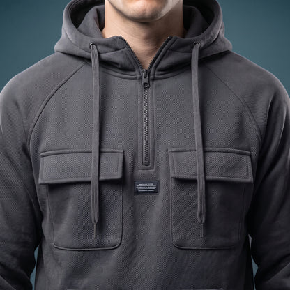 Renholt Utility Hoodie close-up detail - half zip, hood drawcords, flap pockets and woven chest label