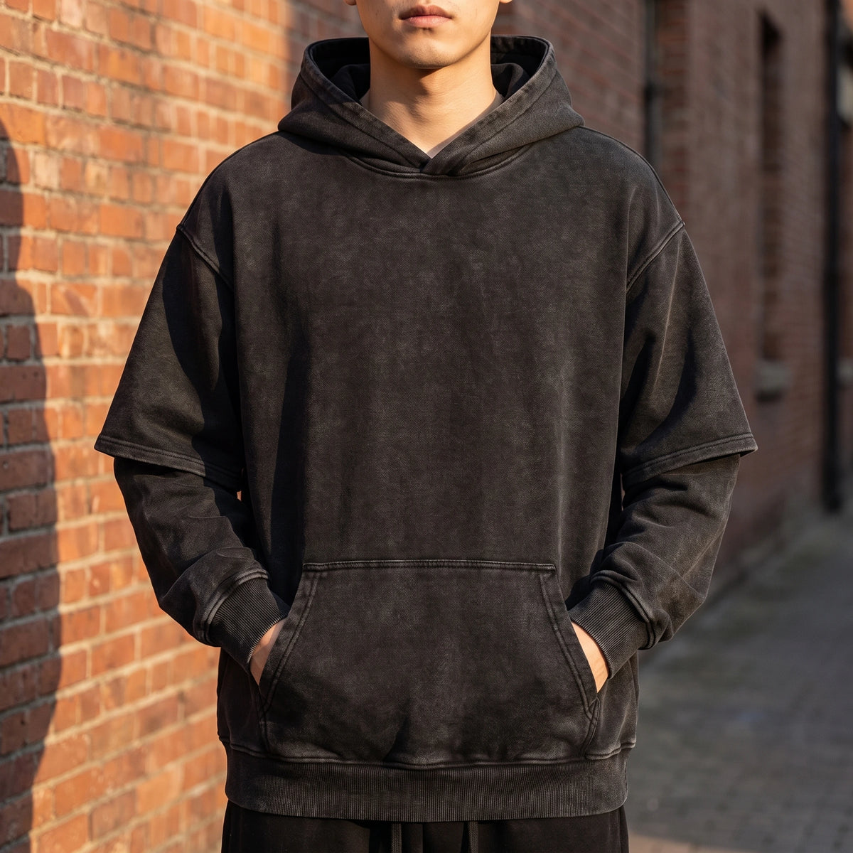 Corsten Washed Hoodie in Black, washed cotton oversized pullover hoodie with layered fake two-piece sleeves, worn front view