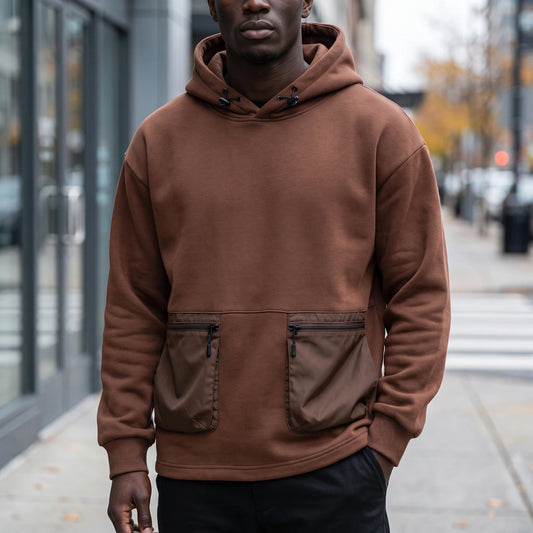 Draven Cargo Hoodie in brown, men's oversized pullover hoodie with two zip cargo pockets, worn front view on city street