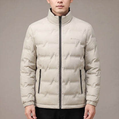 Halden Down Puffer in beige, men's short quilted puffer jacket with dark stand collar, worn in studio