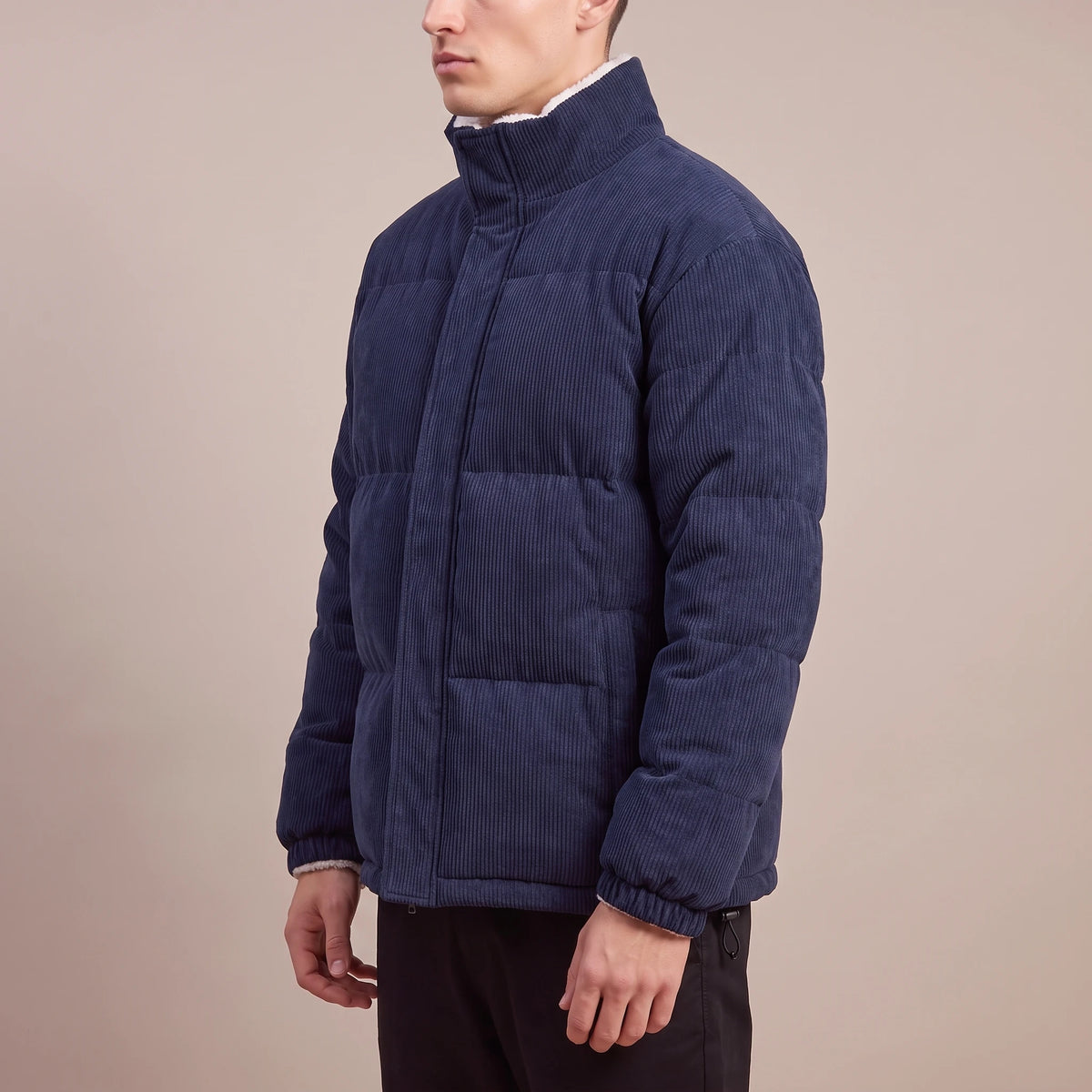 Morvane Fleece Puffer navy corduroy puffer jacket, side view on model showing quilted channels and stand collar
