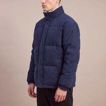 Morvane Fleece Puffer navy corduroy puffer jacket, side view on model showing quilted channels and stand collar