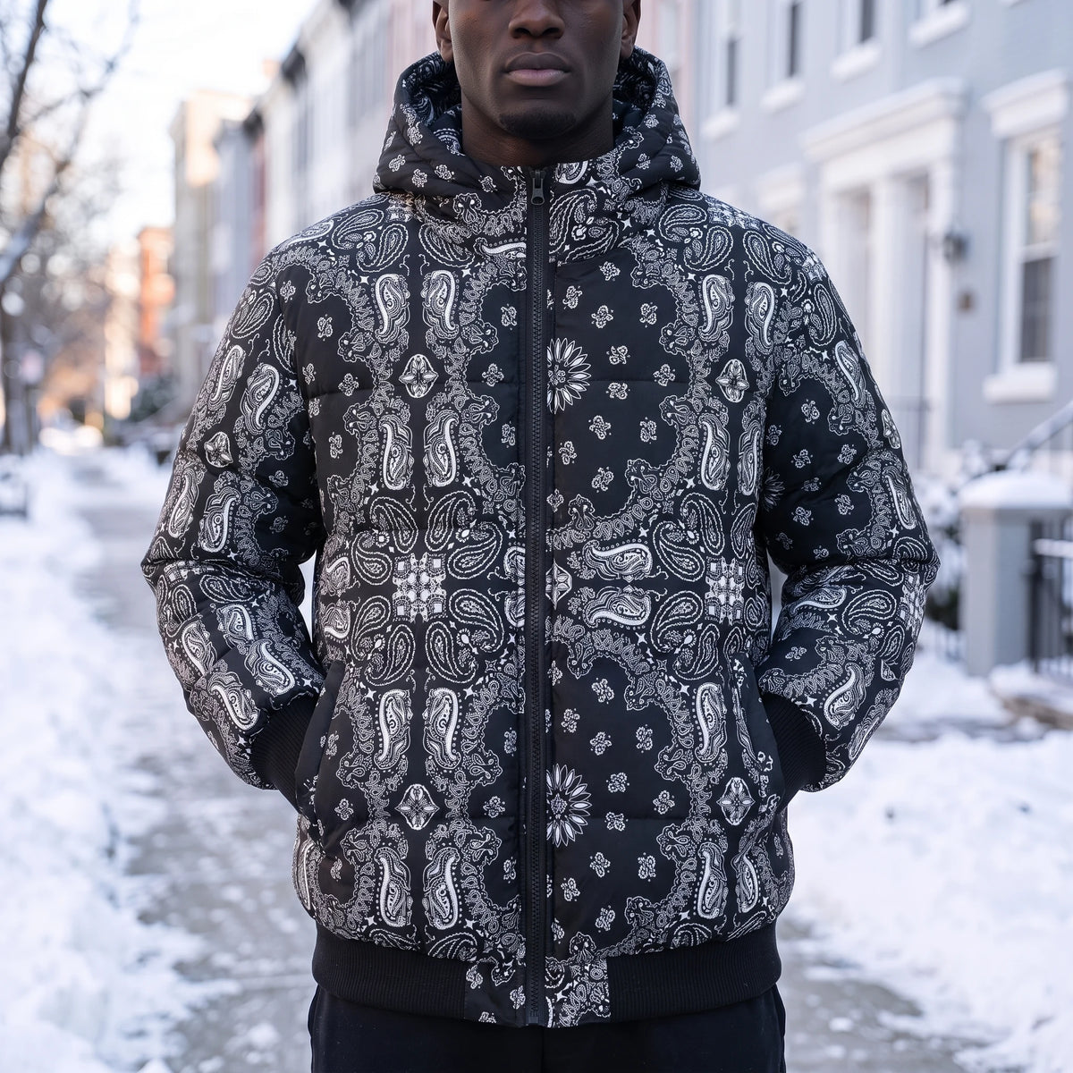 Rennick Paisley Puffer in black, men's black paisley bandana print hooded puffer jacket, worn on snowy street