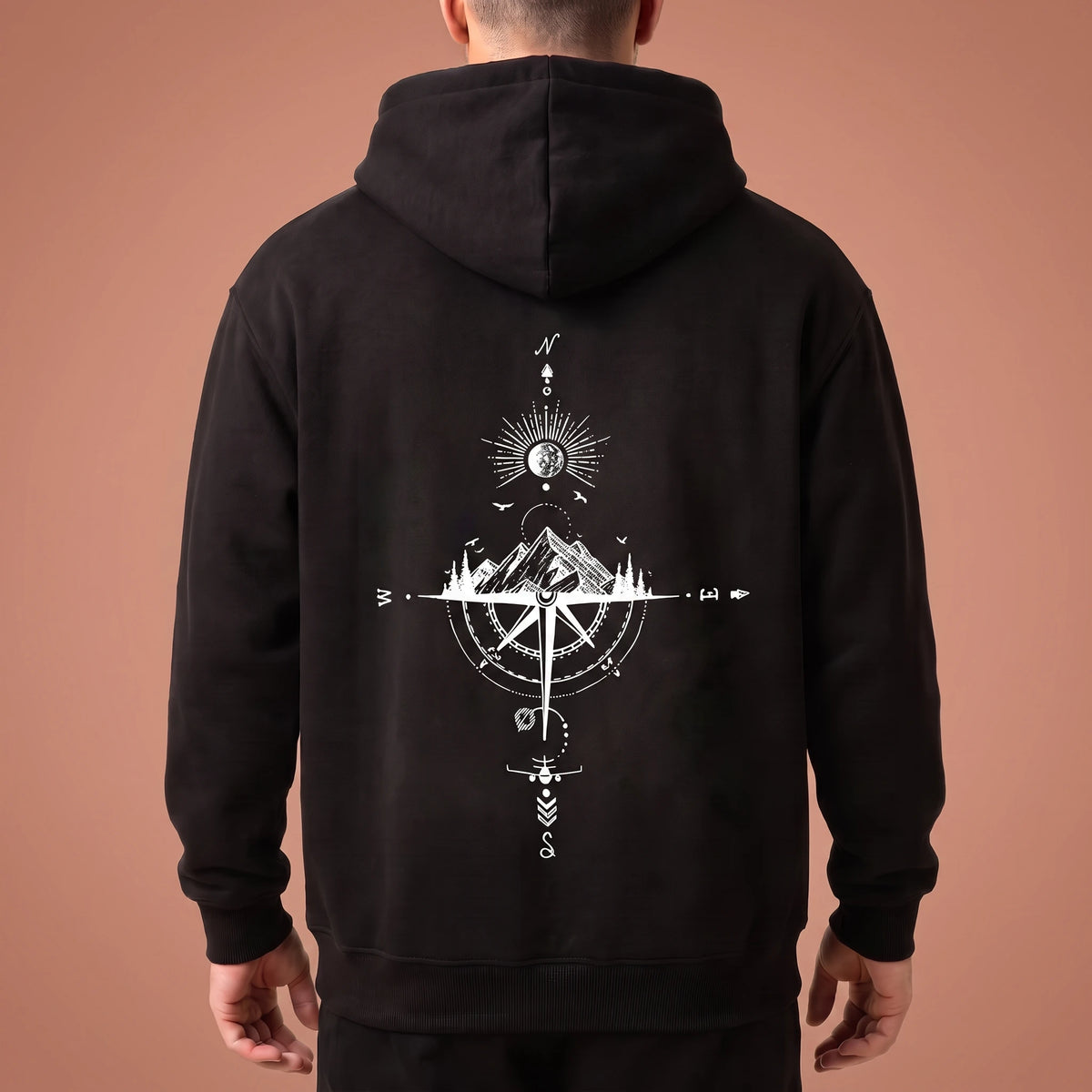 Solane Compass Hoodie in black, oversized pullover with white compass and mountain line drawing across the back panel, worn by model