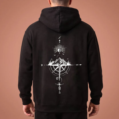 Solane Compass Hoodie in black, oversized pullover with white compass and mountain line drawing across the back panel, worn by model