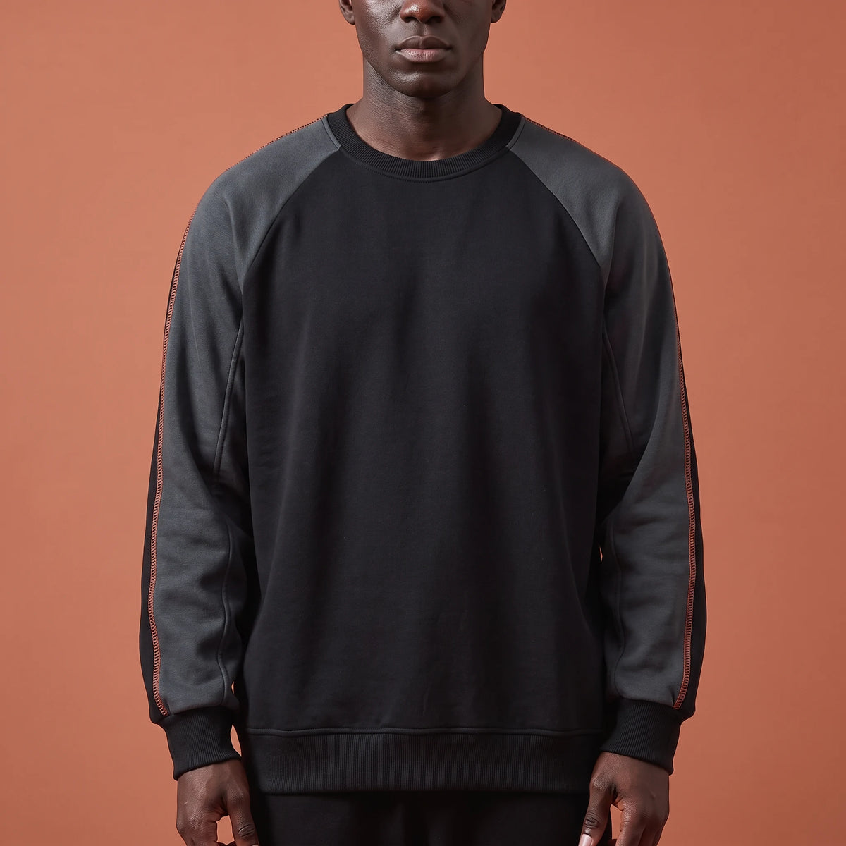 Tavish Stitch Crewneck in black, men's raglan crewneck sweatshirt with charcoal contrast sleeves and orange stitch line