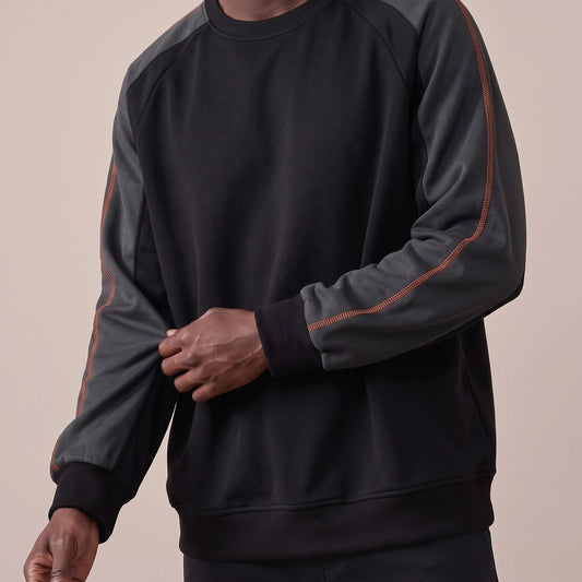 Tavish Stitch Crewneck in black, men's raglan crewneck sweatshirt with charcoal sleeves and orange stitch line, worn