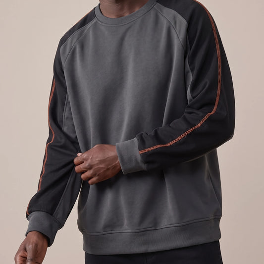 Tavish Stitch Crewneck in gray, men's raglan crewneck sweatshirt with black contrast sleeves and orange stitch line, worn