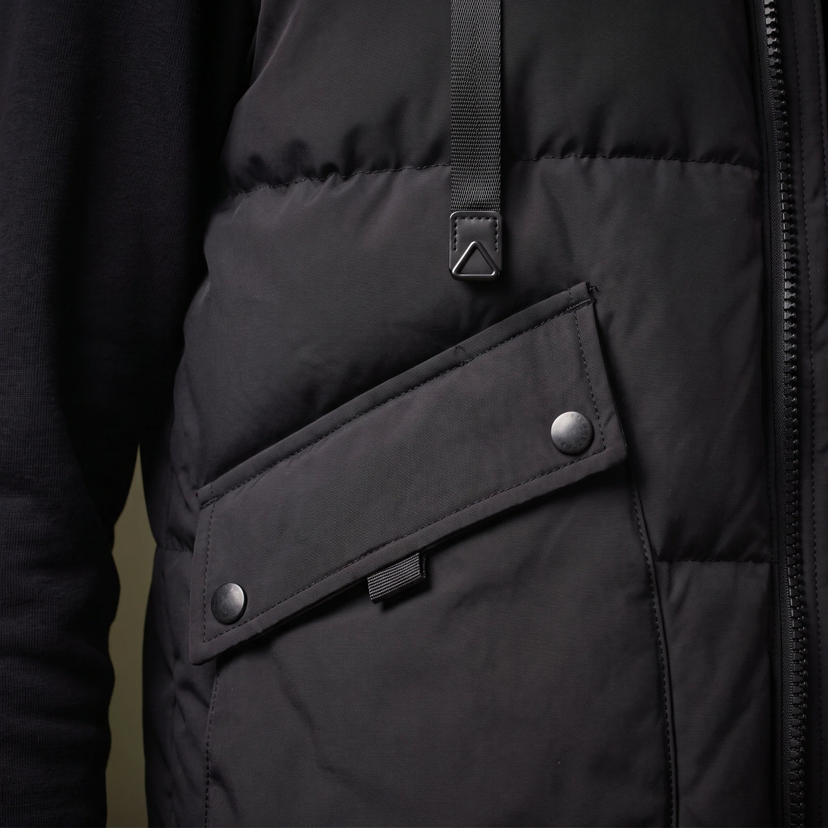 Norvell Hooded Gilet close-up detail of the flap pocket, press stud, welt zip and webbing strap tab