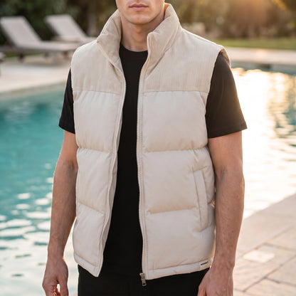Brancourt Puffer Vest in Cream - quilted sleeveless vest with corduroy stand collar worn by a model poolside