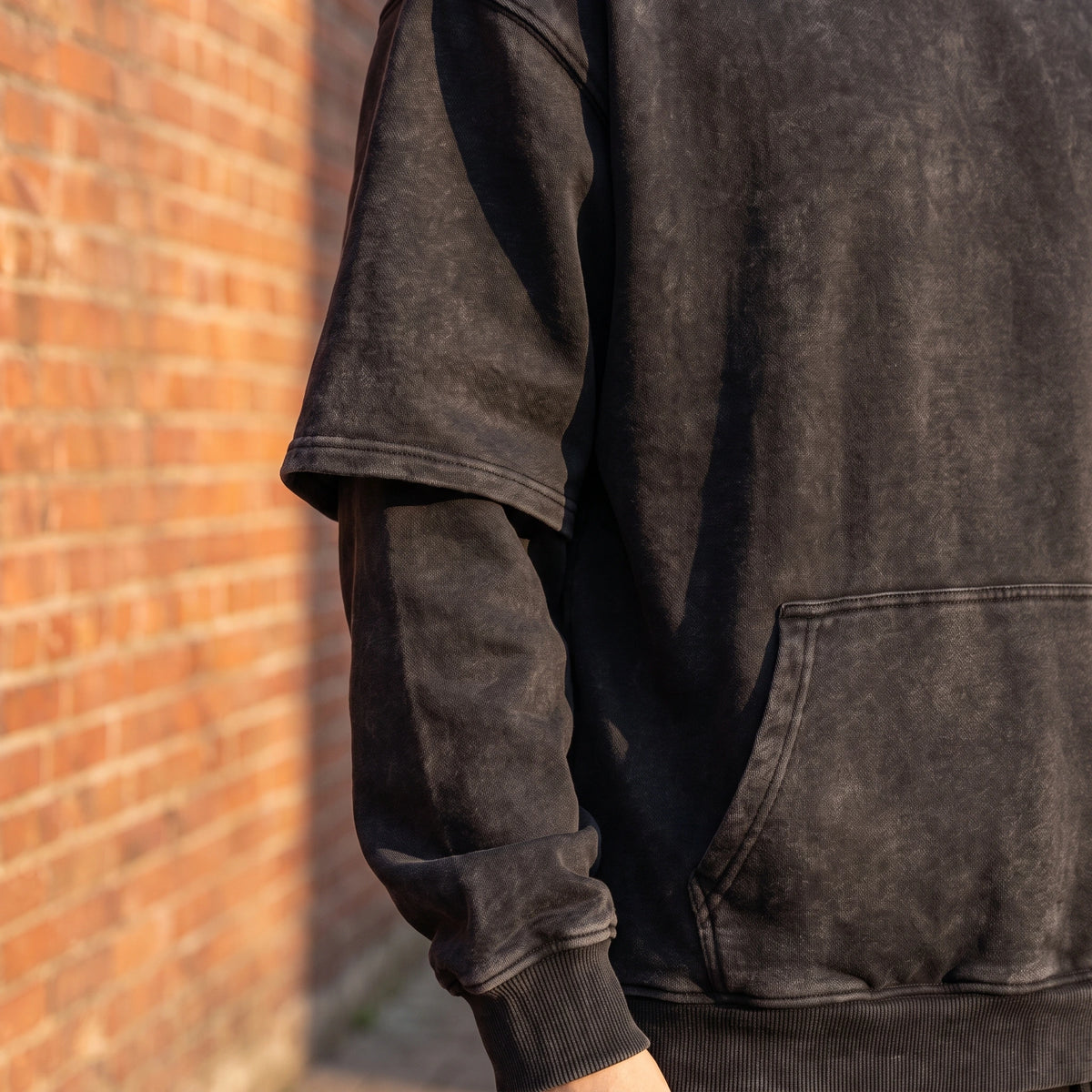 Corsten Washed Hoodie close up of the layered fake two-piece sleeve seam, ribbed cuff and kangaroo pouch