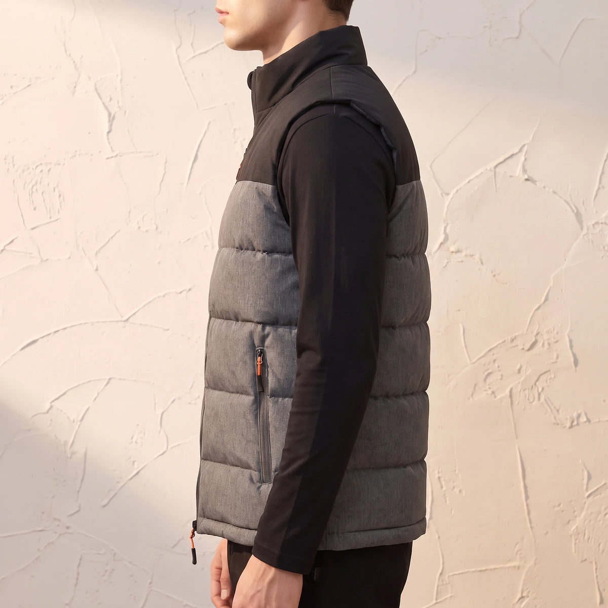 Halvard Padded Vest in Black - side view showing zipped hip pocket and bound armhole