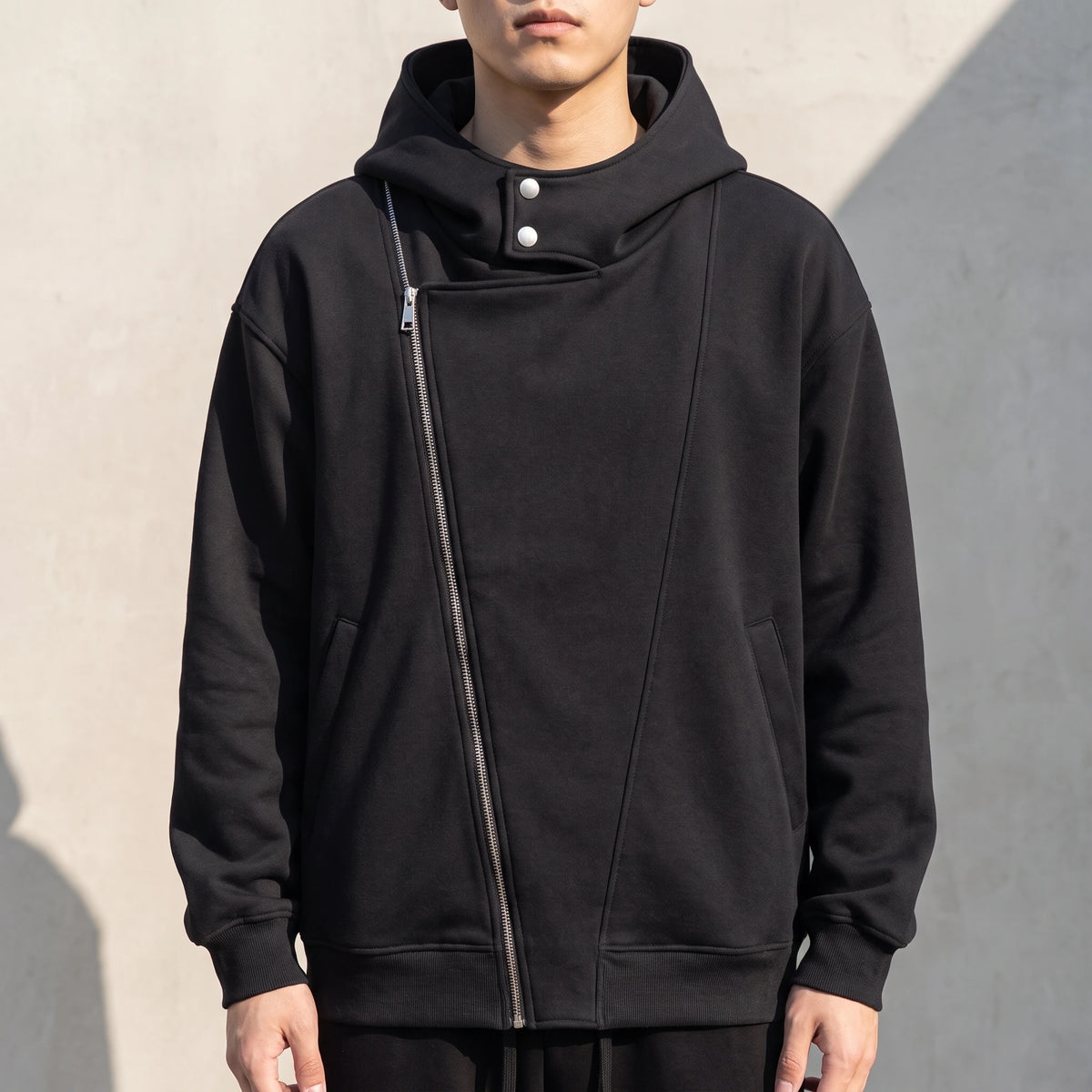 Solteri Collared Hoodie in Black, oversized bonded fleece hooded jacket with asymmetric diagonal zip and snap storm collar, worn front view