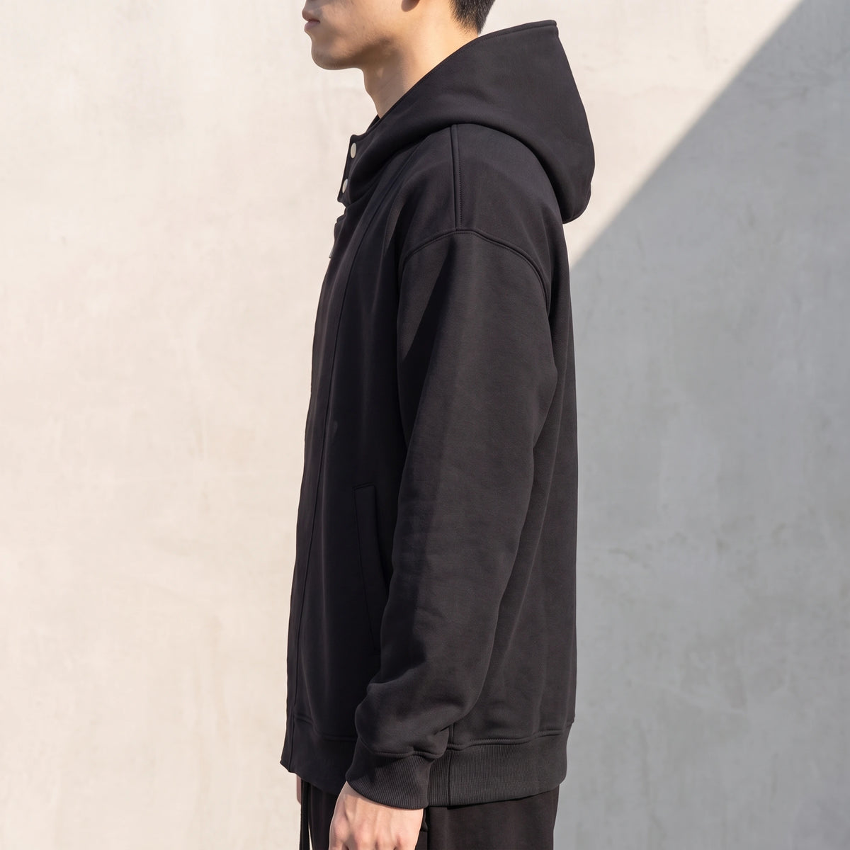 Solteri Collared Hoodie side view showing the oversized drop-shoulder fit and hood resting on the shoulders