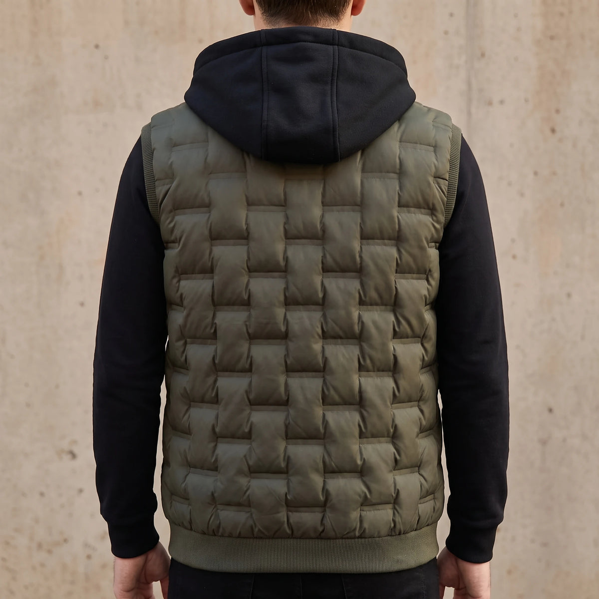 Merrow Padded Vest back view showing the plain box-quilted back panel, ribbed hem band and black hood